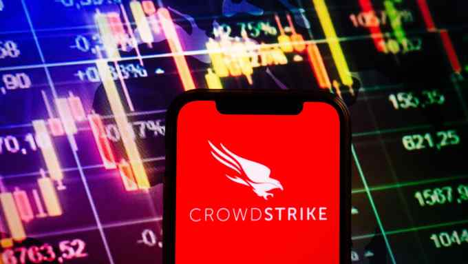 Smartphone displaying logo of CrowdStrike company on stock exchange diagram background