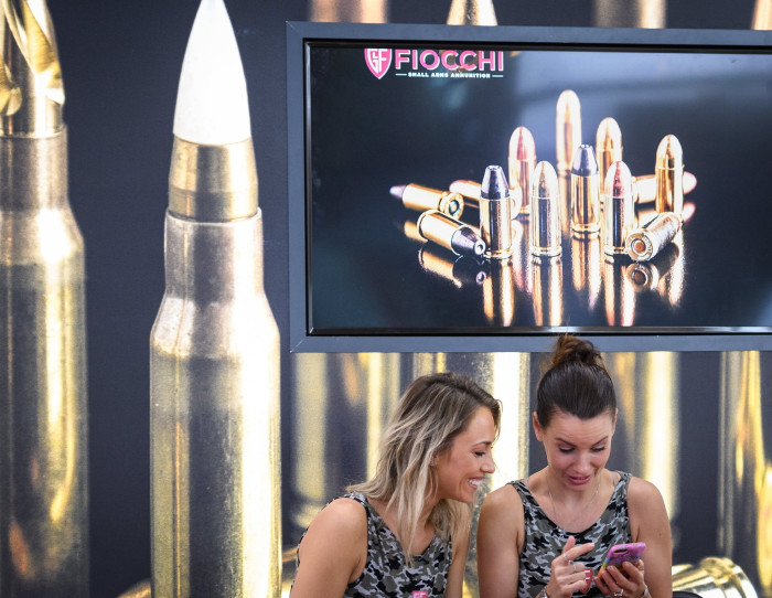 Employees chat at the Fiocchi Ammunition stand at an arms fair in London