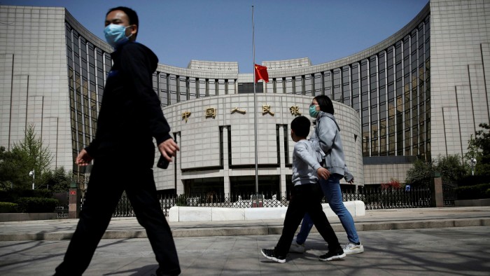 Pedestrians walk past the People’s Bank of China’s headquarters in Beijing, in China