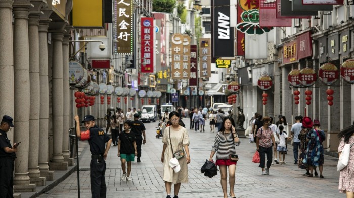 Pedestrians pass stores in Guangzhou, China