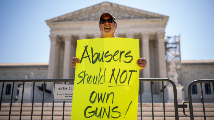 Patrick Mahoney, head of the Christian Defense Coalition, holds a sign reading “Abusers should not own guns!” outside of the US Supreme Court on Friday