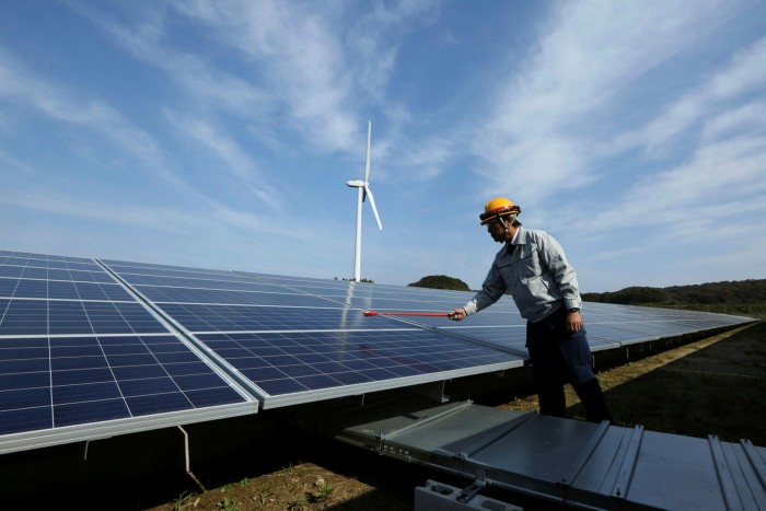 An engineer inspects solar panels during a media tour of Banpu Power Pcl’s solar plant in Awaji, Hyogo, Japan