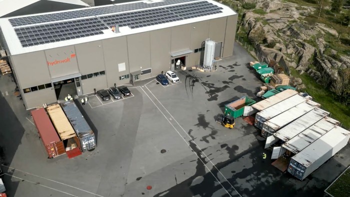 An aerial photo of an industrial building with a roof covered with solar panels