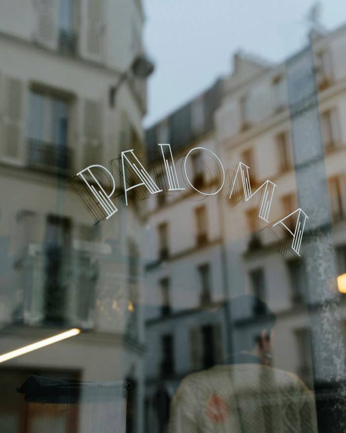 One of the Paloma’s windows photographed from the outside, with the street reflected in i