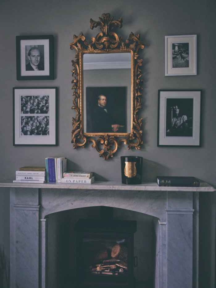 A marble fireplace and family portraits in the Study Room