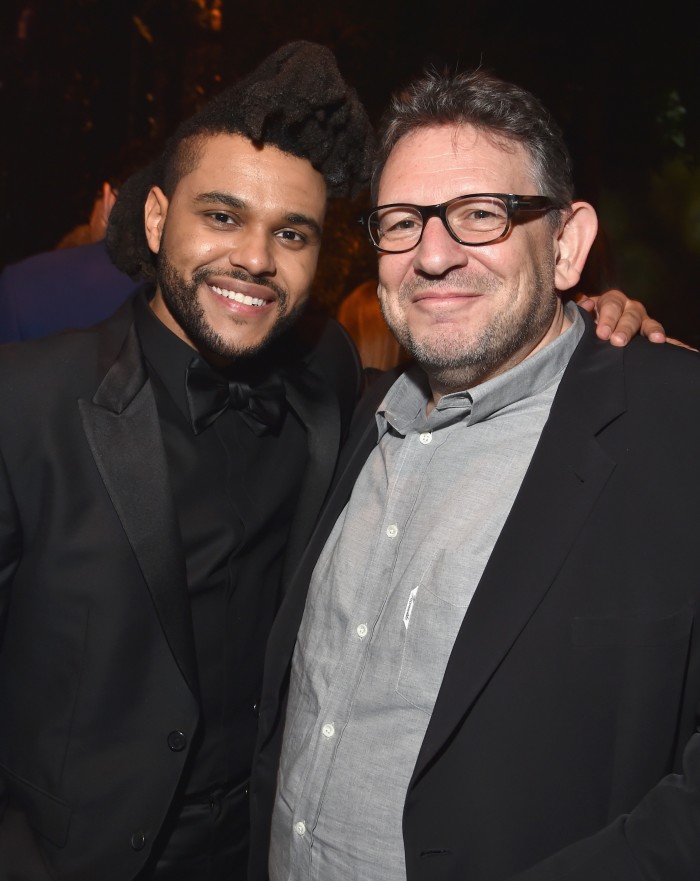 The artist named The Weeknd with his left arm around music executive Lucian Grainge