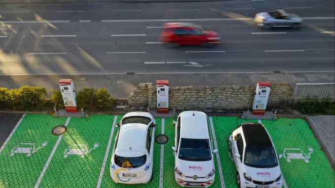 Electric automobiles sit parked in bays as they charge