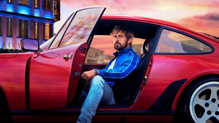 Ryan Gosling seated inside a sports car