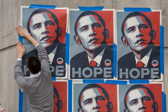 A supporter pastes up posters of Barack Obama in Austin, Texas, 2008