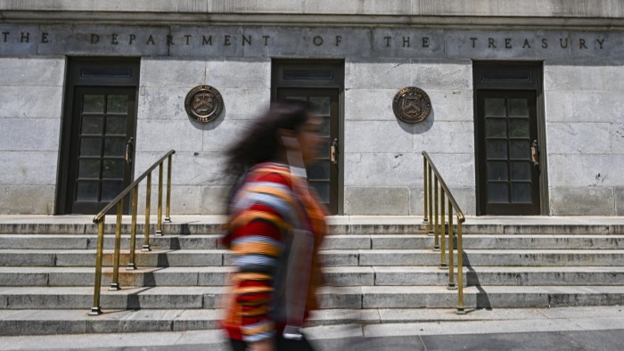 A blurred shot of a woman walking past the United States Department of the Treasury building in Washington, United States