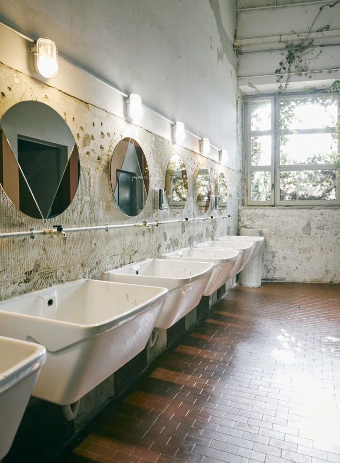 Building 9’s interior spaces are designed by Florentine studio Studio Q-Bic – here, sinks in the restroom are made with reclaimed materials from the construction site