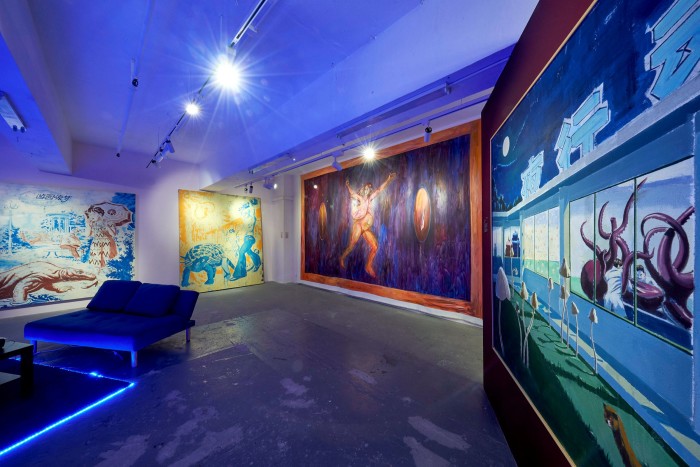 The interior of an art gallery exhibition showing large paintings of animals and sea creatures covering the walls