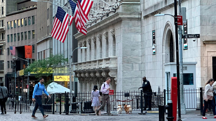 Exterior view of the New York Stock Exchange, with people walking past the building