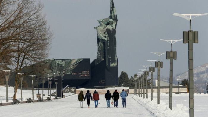 People walk towards the Monument to the Liberators of Donbas in Donetsk, Ukraine