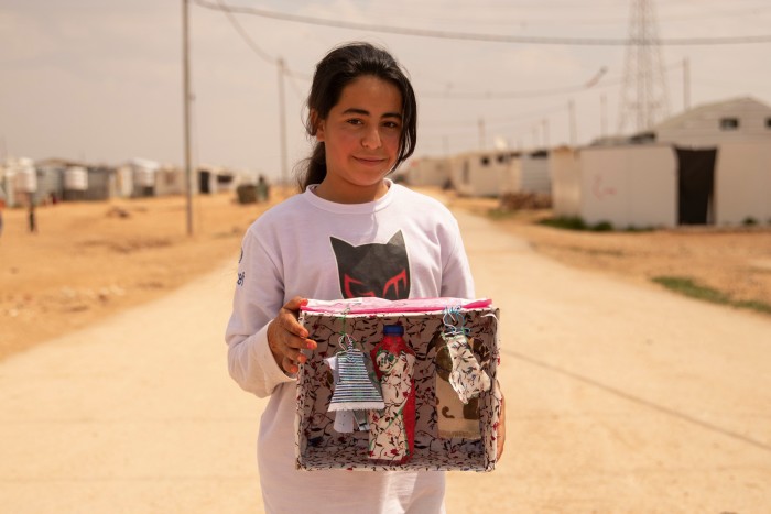 Mariam, 12, with her box at Za’atari refugee camp