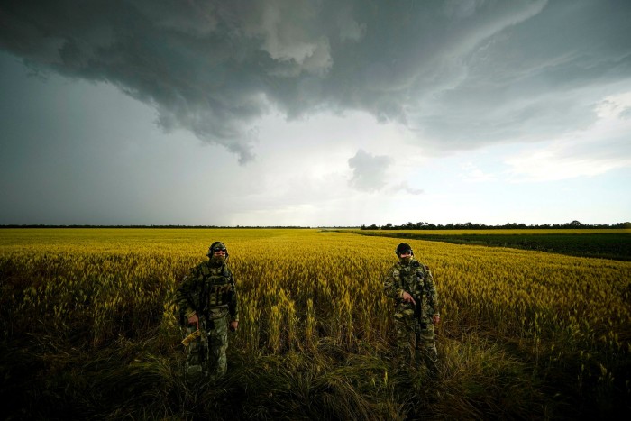 Russian soldiers guard an area next to a field of wheat as foreign journalists work in the Zaporizhzhia region in an area under Russian military control in southeastern Ukraine on June 14