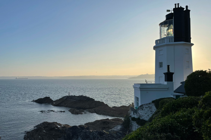 A white lighthouse at sunset