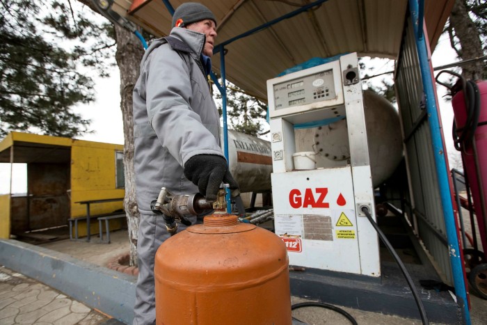 A man fills a gas cylinder at a petrol station in Stefan Voda, Moldova