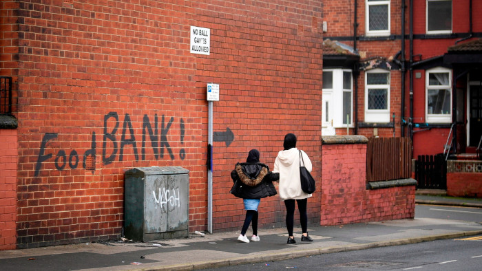 A sign painted on the side of a house directs people to a local food bank in Leeds