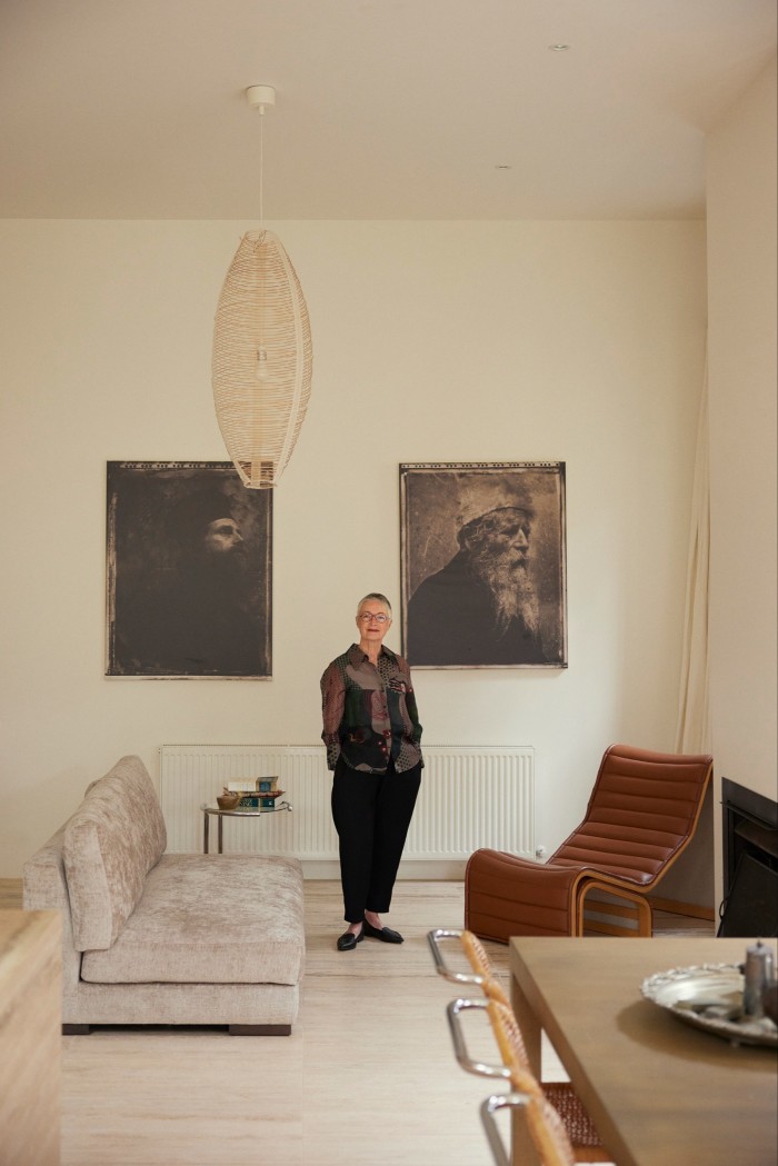 Santos in her living room. On the wall hangs an artwork by Emmanuel Santos