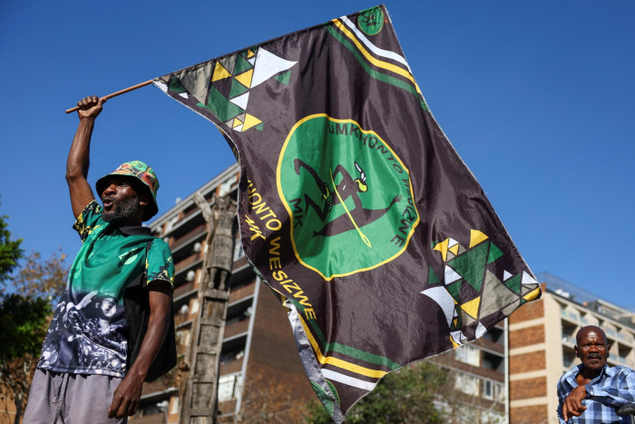 A supporter of the uMkhonto weSizwe Party holds a flag during a gathering in Johannesburg