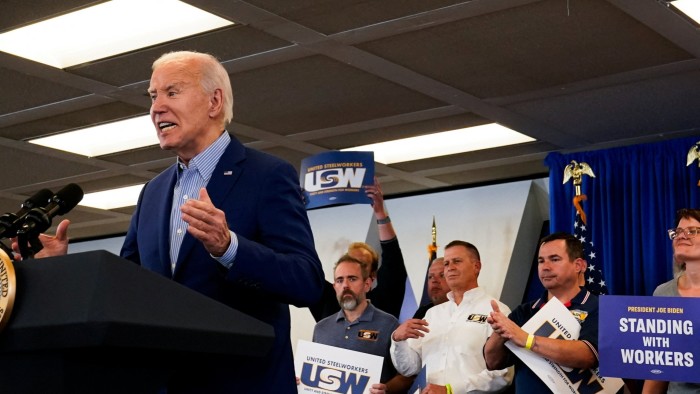Joe Biden, speaking at a podium, with union members in the background