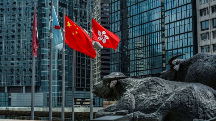 The flag of the Hong Kong Special Administrative Region, right, flies alongside the flag of China outside the Exchange Square complex