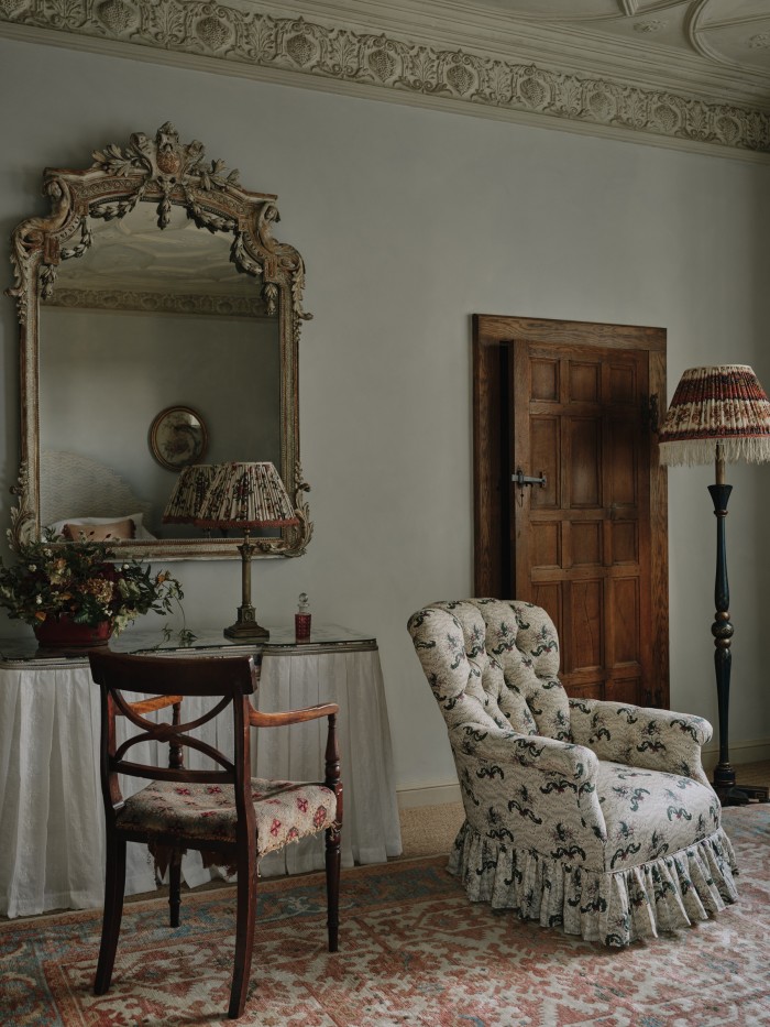 A 19th-century spoon-back armchair upholstered in Flora Soames Daphne fabric, £4,500, early-20th-century linen lampshade (on left), £1,050, and mid-19th-century wool lampshade, £1,350