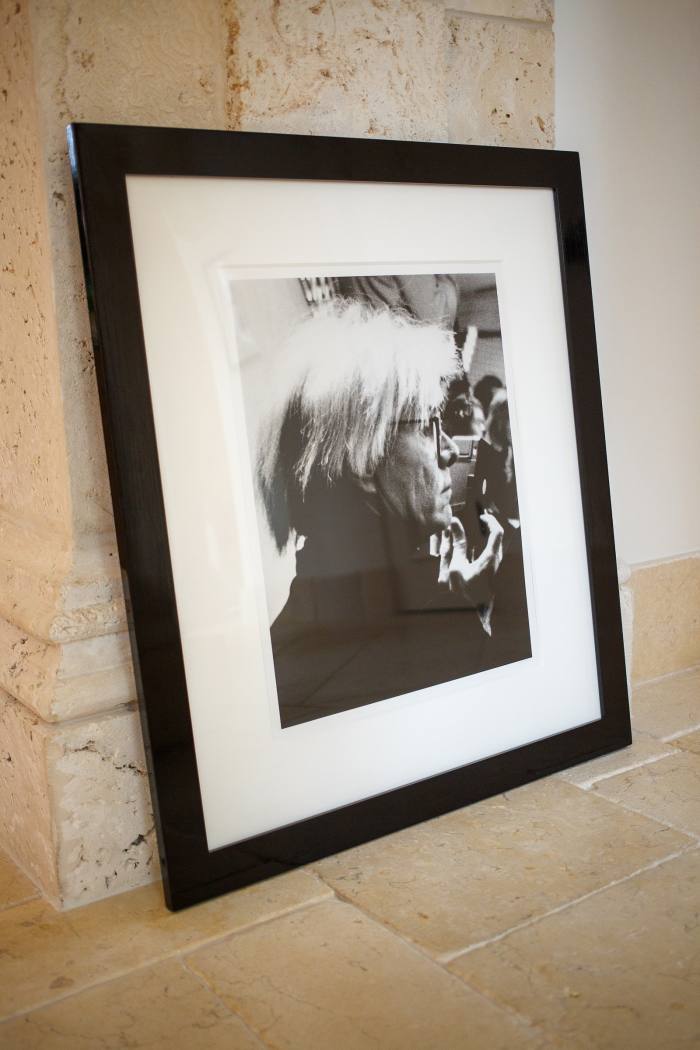 A framed black and white portrait of Andy Warhol