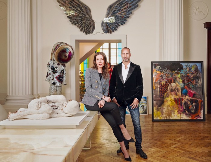 Deanna Leontieva and Rami Fustok at his London home with, clockwise from above left: Feather Child 1 by Lucy Glendinning, £12,000; Soundsuit by Nick Cave, $100,000; wings made of strips of paper by Greek artist Pavlos Dionyssopoulos, €160,000; and a commission by Jonas Burgert, €80,000