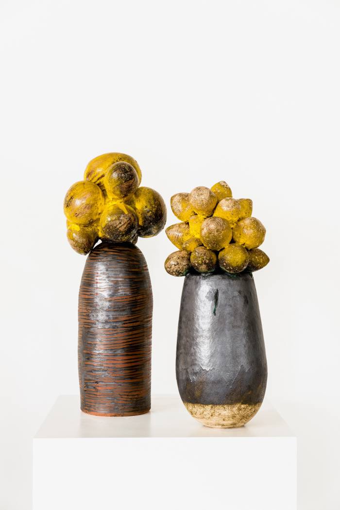 Two of her glazed clay stoneware sculptures, "Umthwalo – Dadobawo" (left) and “Weniamo – Baobab Series” (right)