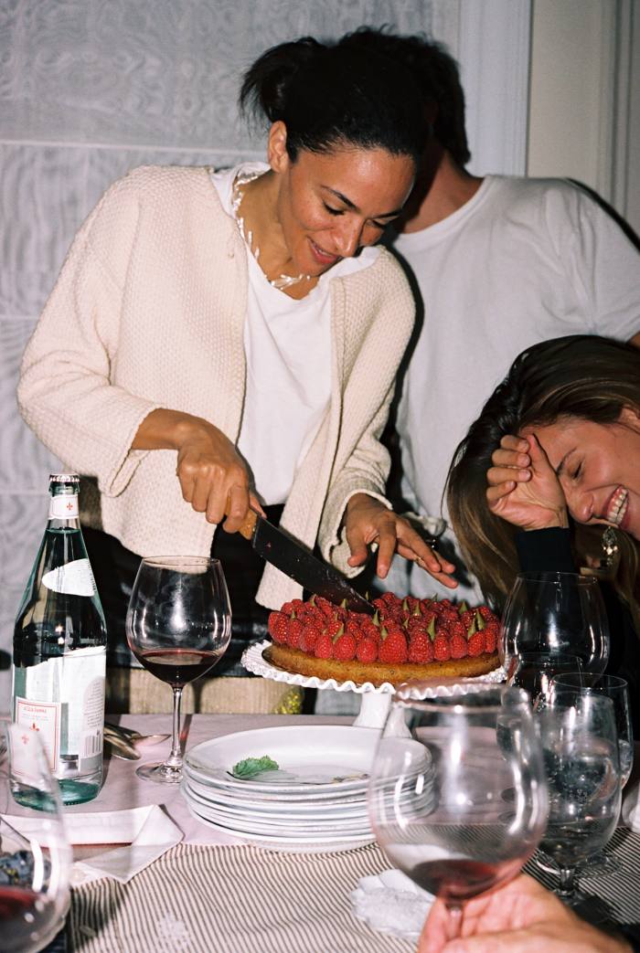 Laila slices the raspberry tart for dessert, with her partner Ignacio Mattos (behind her) and guest Dianna Agron