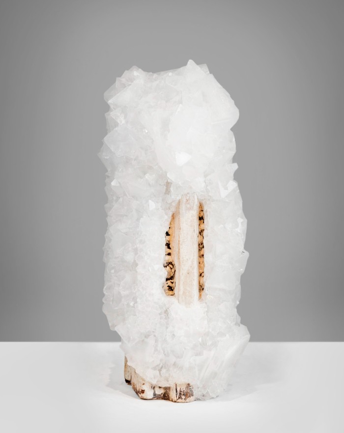 White crystals growing over a small stone obelisk