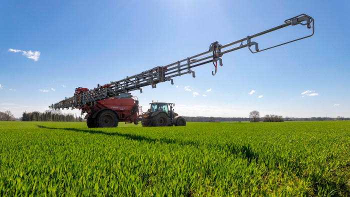 A tractor spreads fertilizer 