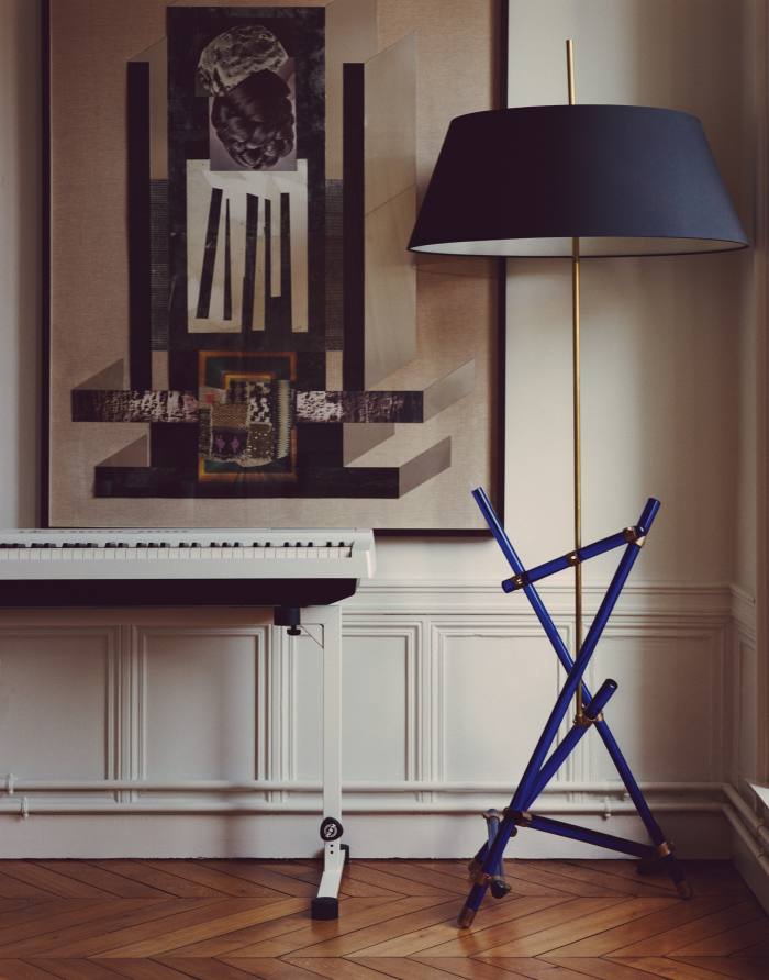 A Yamaha digital piano and vintage Italian lamp in front of a Ben Sansbury collage