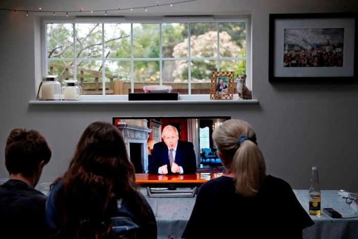 A family gathers round a TV to watch UK prime minister Boris Johnson’s televised message on coronavirus on May 10