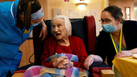 Carer Sue Gwenlan (L) and Deputy Manager Anne Frearson (R), who remains on site with six colleagues, talk to resident Vera Bull at Fremantle Trust care home, amid the outbreak of the coronavirus disease (COVID-19), in Princes Risborough, Britain, May 4, 2020. Picture taken May 4, 2020. REUTERS/Eddie Keogh