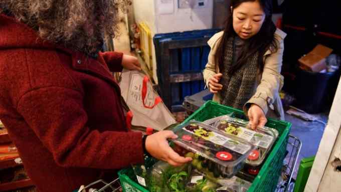 FoodCycle volunteers Clare Allen (L) and Renny Yeun (R) collect food donated by Waitrose supermarket in London on December 21, 2016. One of Europe's worst offenders on food waste, Britain is beginning to get its act together thanks to a surge in volunteer initiatives that help the poor as well as creating a bit of seasonal cheer. / AFP / BEN STANSALL / TO GO WITH AFP STORY by ROSIE SCAMMELL (Photo credit should read BEN STANSALL/AFP/Getty Images)