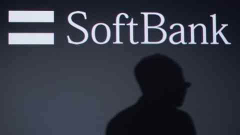 The shadow of Ken Miyauchi, executive vice president at SoftBank Corp. and chief executive officer of SoftBank's mobile unit, is cast against a screen displaying the company's logo during a product launch in Tokyo, Japan, on Tuesday, May 19, 2015. SoftBank's Japanese mobile business added a net 1.8 million subscribers in the year ended March bringing the total to 37.77 million, the company reported last week. Photographer: Kiyoshi Ota/Bloomberg