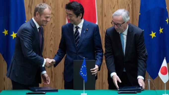 epa06894391 Japanese Prime Minister Shinzo Abe (C) shakes hands with the President of the European Union's commission Jean-Claude Junker (R) and European Union's council president Donald Tusk (L) after signing a contract at the Japanese Prime Minister office in Tokyo, Japan, 17 July 2018. EPA/MARTIN BUREAU / POOL