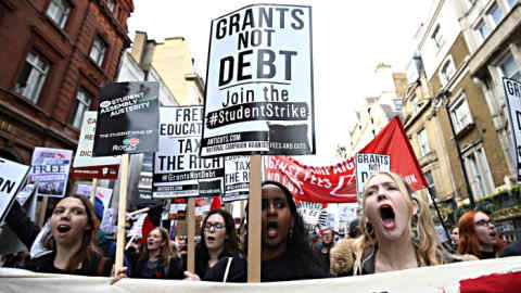 Protesters march with placards and banners against student fees during an annual demonstration in central London on November 4, 2015. Students marched calling for free university education for all. Fees for university students in England were introduced in 1998 and the maximum allowable charge was trebled by the previous coalition government led by Prime Minister David Cameron to up to 9,000 (12,000 euros, 13,000 USD) GBP per year. AFP PHOTO / JUSTIN TALLIS (Photo credit should read JUSTIN TALLIS/AFP/Getty Images)