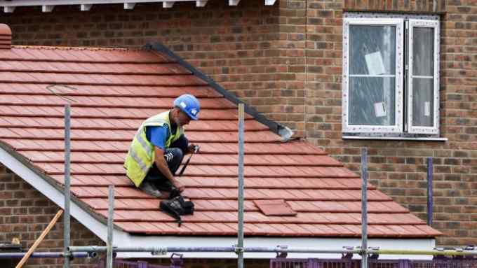 A workman prepares to fix tiles to a roof on a housing development under construction in Maldon, U.K., on Thursday, June 22, 2017. U.K. house prices recorded their slowest quarterly growth in four years, adding to signs that the market is cooling. Photographer: Chris Ratcliffe/Bloomberg