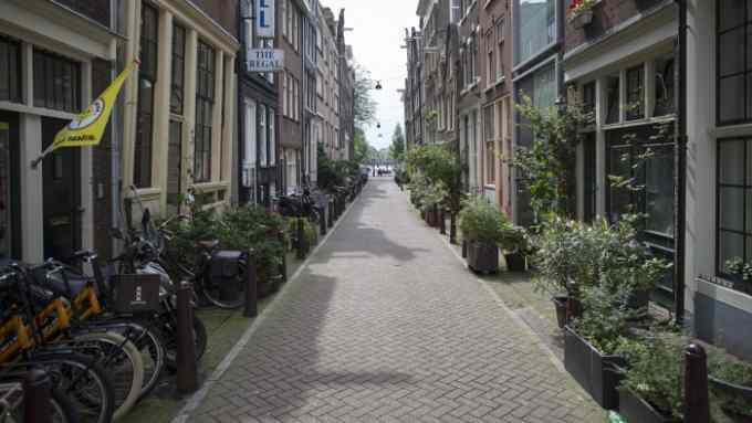 Potted plants sit in front of houses on a residential street in Amsterdam, Netherlands, on Wednesday, Aug. 26, 2015. Seven years after a global financial crisis was sparked by lax lending rules, the Netherlands is the last country in western Europe where homebuyers can borrow as much as 103 percent of the purchase price -- enough to cover a slice of the transaction costs as well. Photographer: Jasper Juinen/Bloomberg