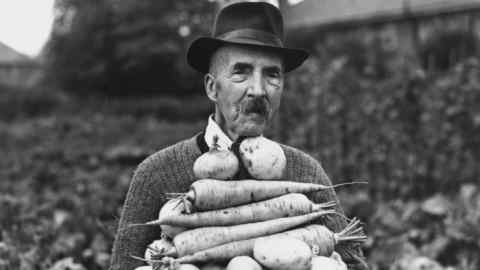 9th October 1942: Champion gardener 89 year old John Hall carries a pile of his prize winning vegetables, at his allotment at Foots Cray. (Photo by Reg Speller/Fox Photos/Getty Images)