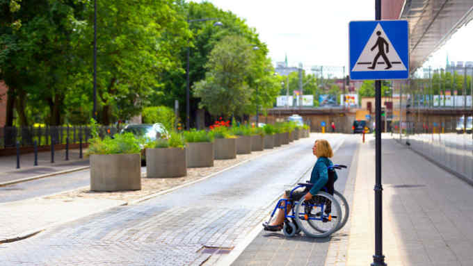adult woman on wheelchair crossing the street in the city
