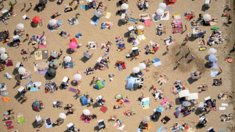 An aerial view shows people crowding the beach of the lake Wannsee in Berlin, eastern Germany, on June 8, 2014. Meteorologists forecast temperatures around 35 degrees for the coming days in Germany. AFP PHOTO / DPA/ RALF HIRSCHBERGER GERMANY OUT (Photo credit should read RALF HIRSCHBERGER/AFP/Getty Images)