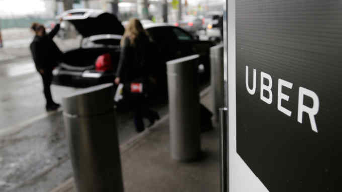 FILE - In this March 15, 2017, file photo, a sign marks a pick-up point for the Uber car service at LaGuardia Airport in New York. Drivers for ride-hailing giants Uber and Lyft are planning to turn off their apps to protest what they say are declining wages at a time when both companies are raking in billions of dollars from investors. (AP Photo/Seth Wenig, File)