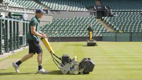 Groundsmen Joe Briggs (left) and Alex Brierley on Centre Court 'vertigrooming' (a light cut to 13mm to remove excess growth). (C) Leo Goddard