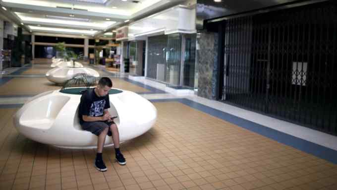 Anthony Russell, 21, sits in the deserted Carousel shopping mall in San Bernardino, California September 11, 2012. The city of about 210,000, some 65 miles (104 km) east of Los Angeles, filed for bankruptcy on August 1, joining the Bay Area city of Stockton as a test case for whether financially troubled municipalities can shed bond payments and possibly pension obligations via bankruptcy court. Picture taken September 11, 2012. To match Special Report BERNARDINO/BANKRUPT REUTERS/Lucy Nicholson (UNITED STATES - Tags: POLITICS BUSINESS) - RTR3ACHK