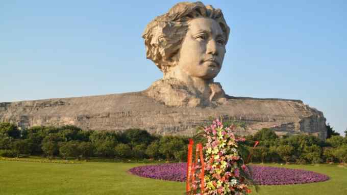 Orange Island park in Hunan Changsha, the head statue of chairman Mao Zedong view behind Chinese old house
